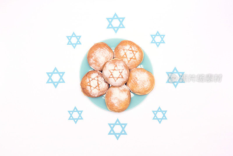 光明节场景与传统的光明节甜甜圈sufganiyot和蓝色的大卫星星在白色的背景。平铺风格与复制空间