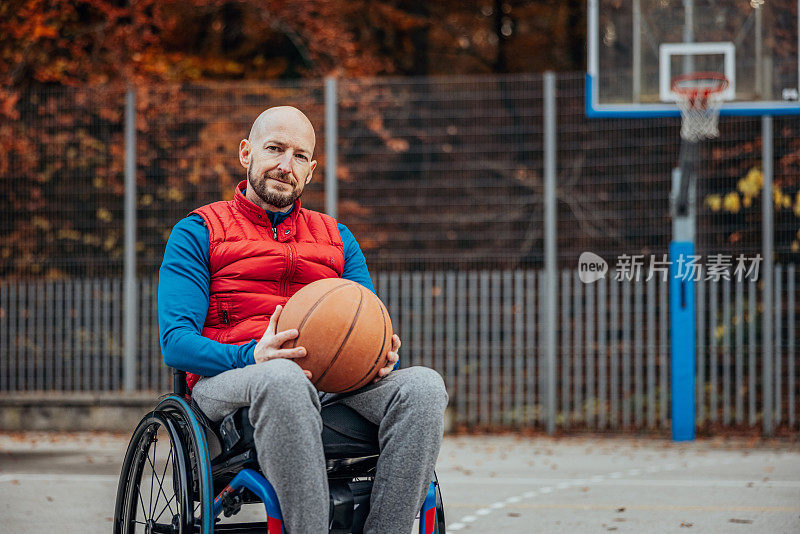残疾人的肖像，轮椅上的一个球在篮球场
