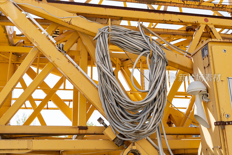 工地起重机上的橙色金属管道相互焊接的特写。用于建筑工地吊装大型货物，工业施工机械。
