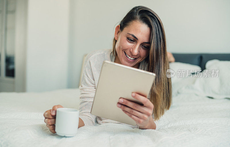 妇女在家里使用电子平板电脑。