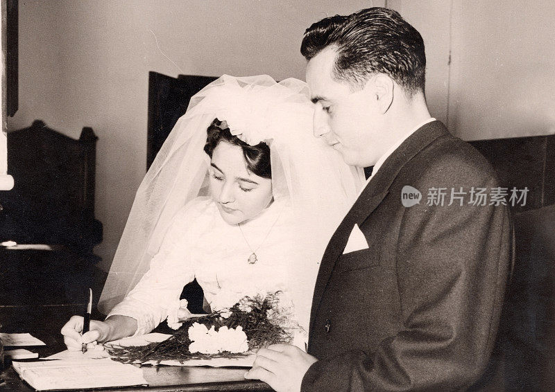 50年代的经典图片:年轻的夫妇在他们的结婚文件上签字