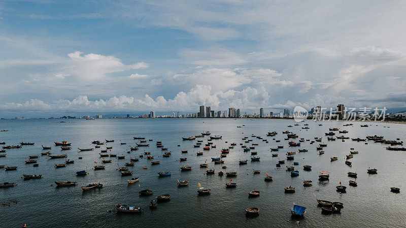 白天越南岘港市的城市景观，摩天大楼和船只在开阔的海上航行