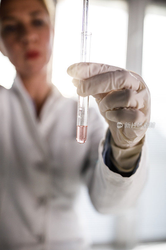 女科学家用移液管从试管中提取样本