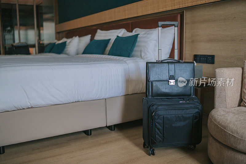 现代酒店客房，有床，床头柜和旅行箱