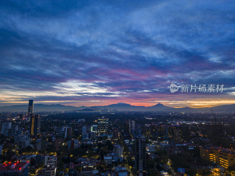 黎明时分的墨西哥城南部天际线上有火山