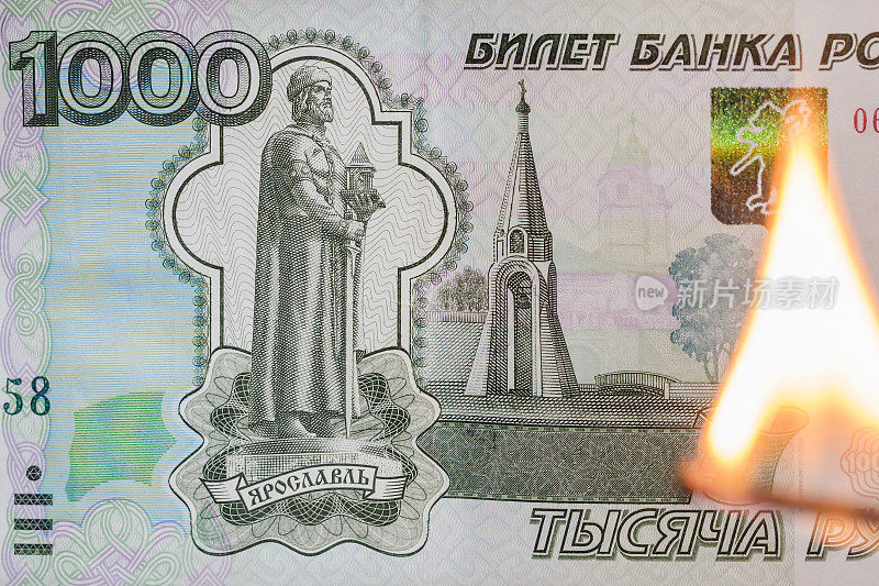 纸币1000卢布和燃烧的火柴。烧俄罗斯钱——商业理念。俄罗斯危机，卢布通胀