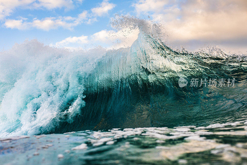 巨大的海浪碰撞在戏剧性的光线中产生了水的爆炸