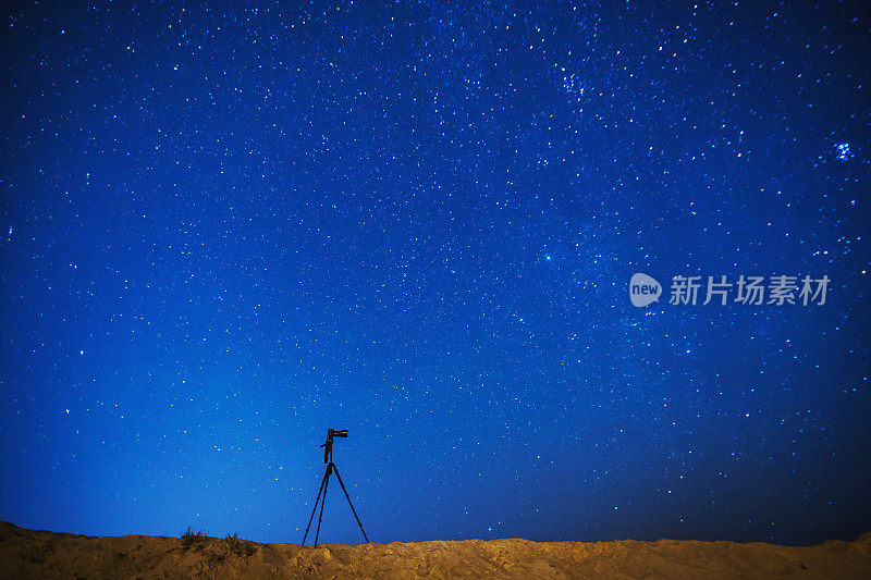 摄影相机在三脚架上的背景上的夜空星空。星星。景观