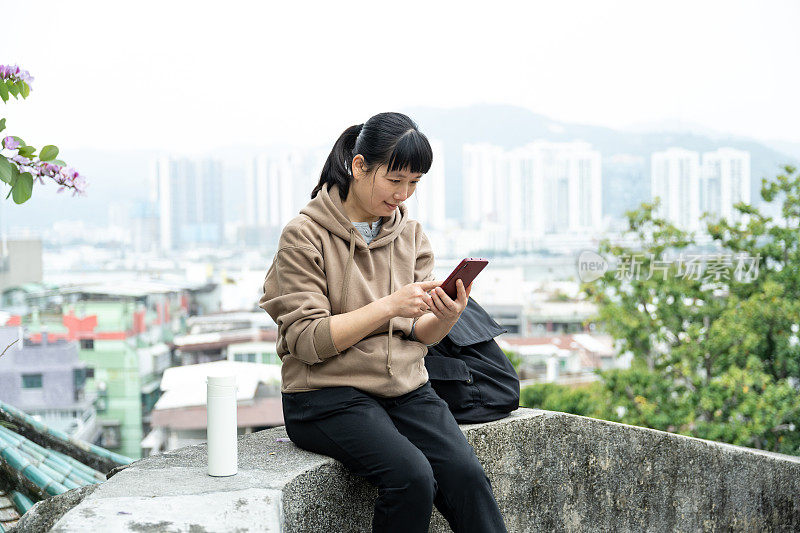 一名女游客在公园平台上看她的手机