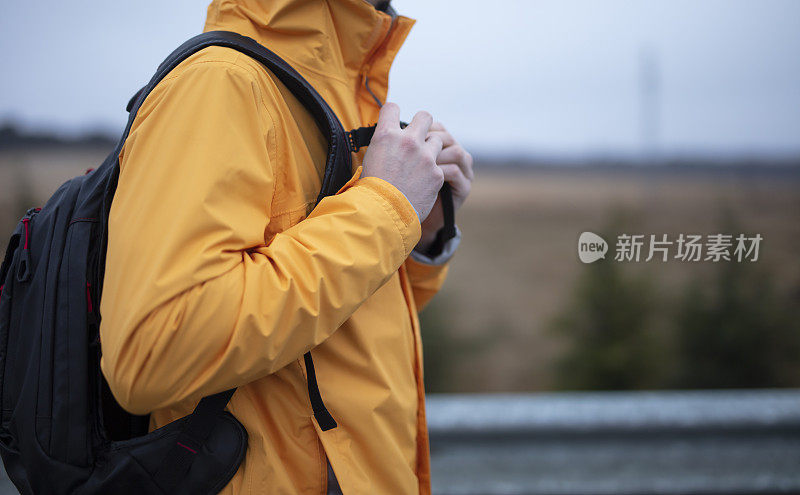 徒步旅行的人带着防水雨衣和背包