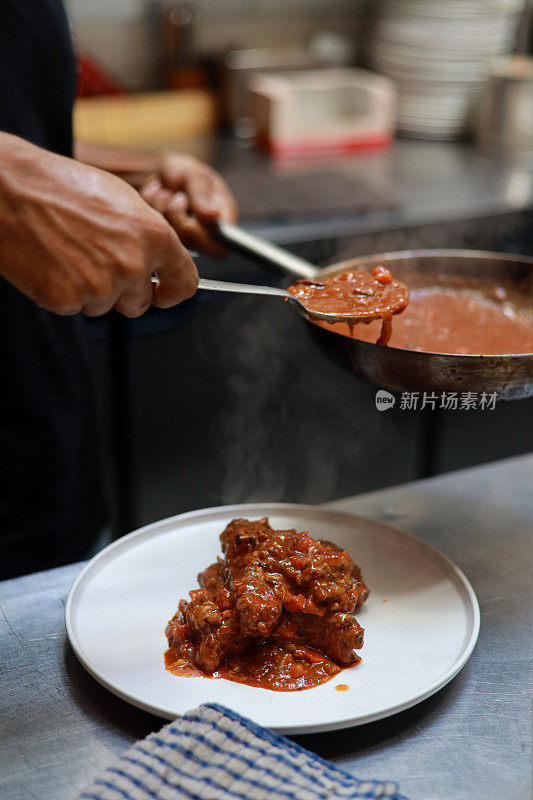 厨师在厨房准备红酒焖排骨