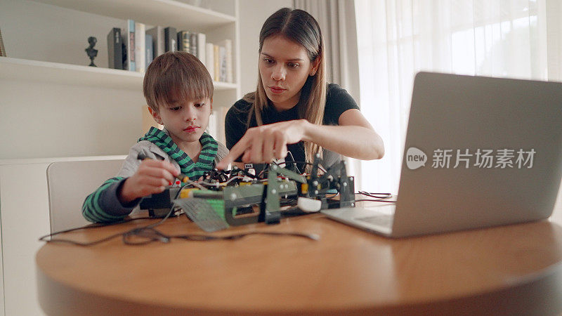 年轻的保姆或姐姐照顾可爱的男孩，帮助组装和修理机器人玩具在家里。教师协助小学生在科学课堂上学习力学、stem。增强想象力的活动。创新与科技