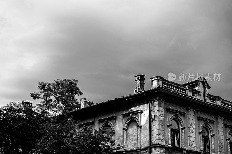 在浓重的灰云下的破旧的几乎被遗弃的房子，黑白色调