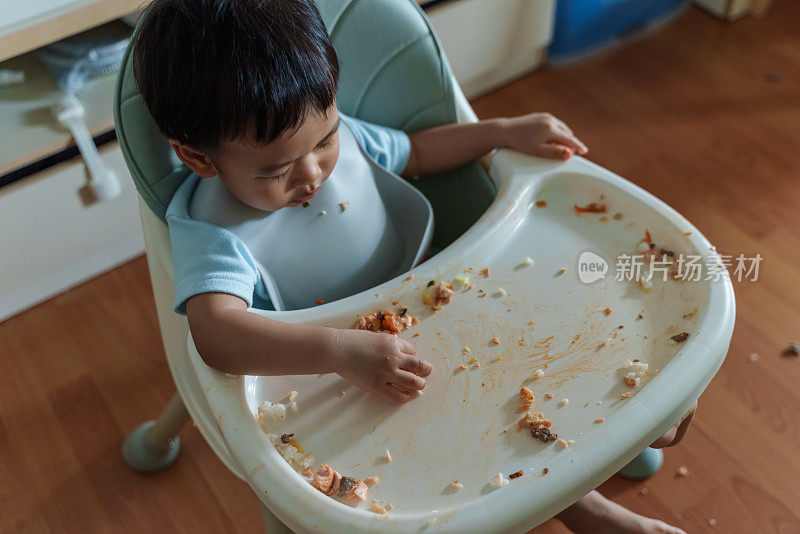 凌乱的宝宝用手自己喂奶。婴儿主导断奶(BLW)概念