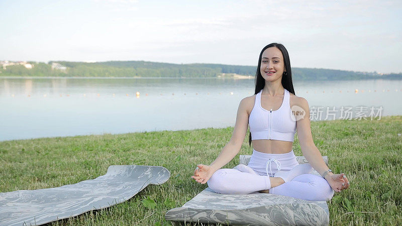 小女孩在湖边做瑜伽。冥想姿势，保健。运动时放松。