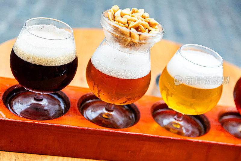 精选比利时啤酒，装在玻璃杯里，但放在木托盘里。