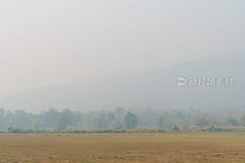 乡村景观山峦被大火烟雾覆盖，森林燃烧，污染问题严重。2.5