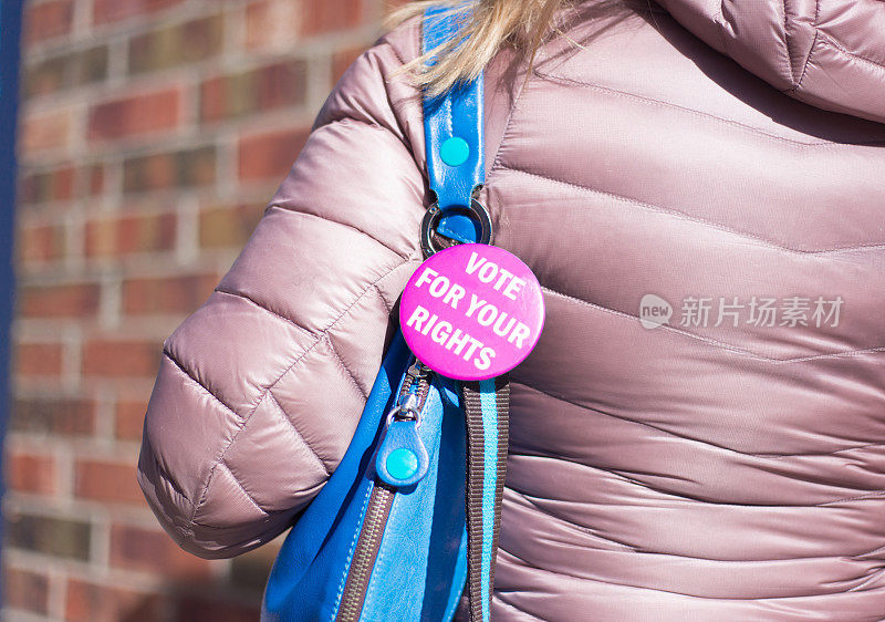 女性钱包上的粉色“为你的权利投票”按钮