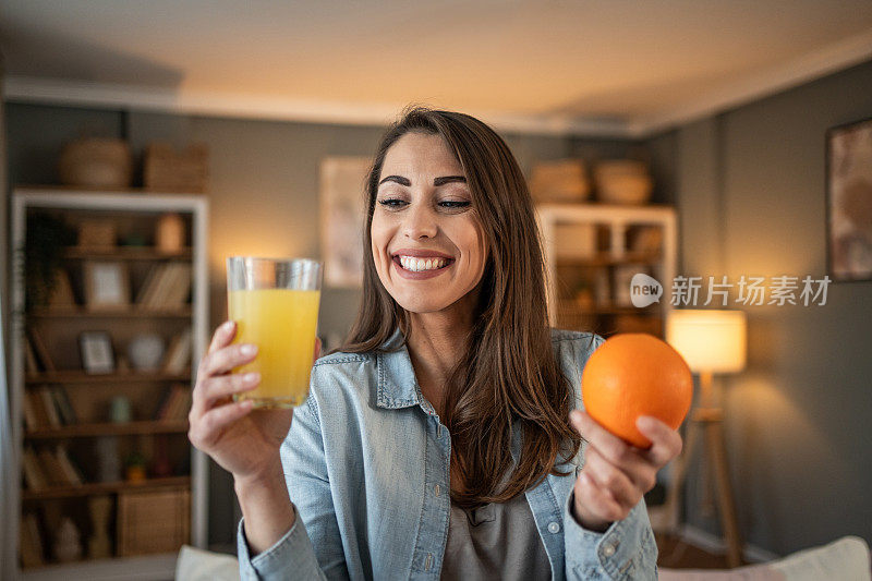 一位年轻女子享受着喝鲜橙汁的时刻