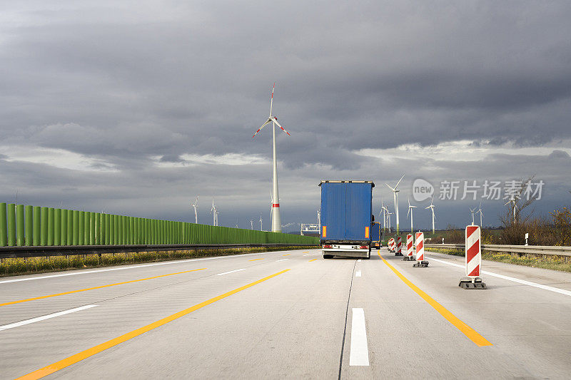 德国高速公路上的卡车，风电场和乌云