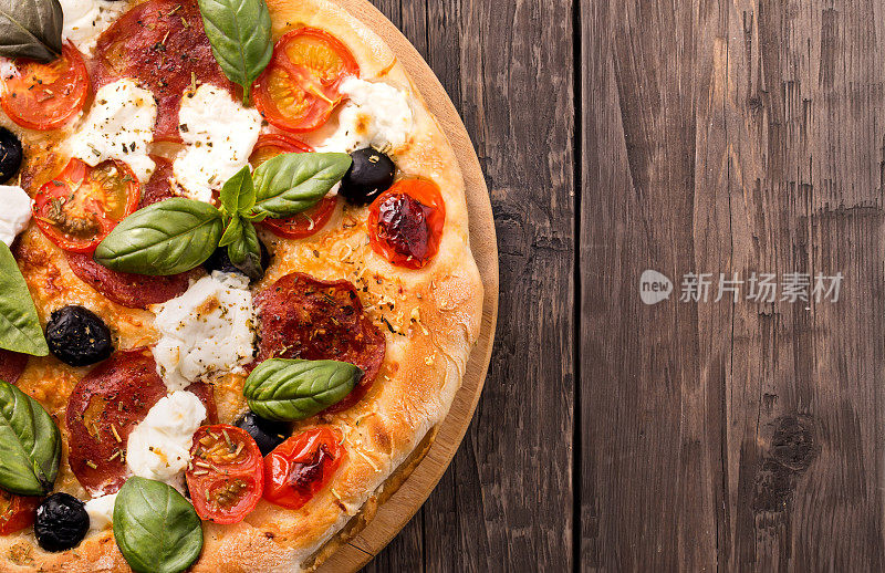 用意大利腊肠、马苏里拉奶酪、橄榄和罗勒木做的乡村披萨