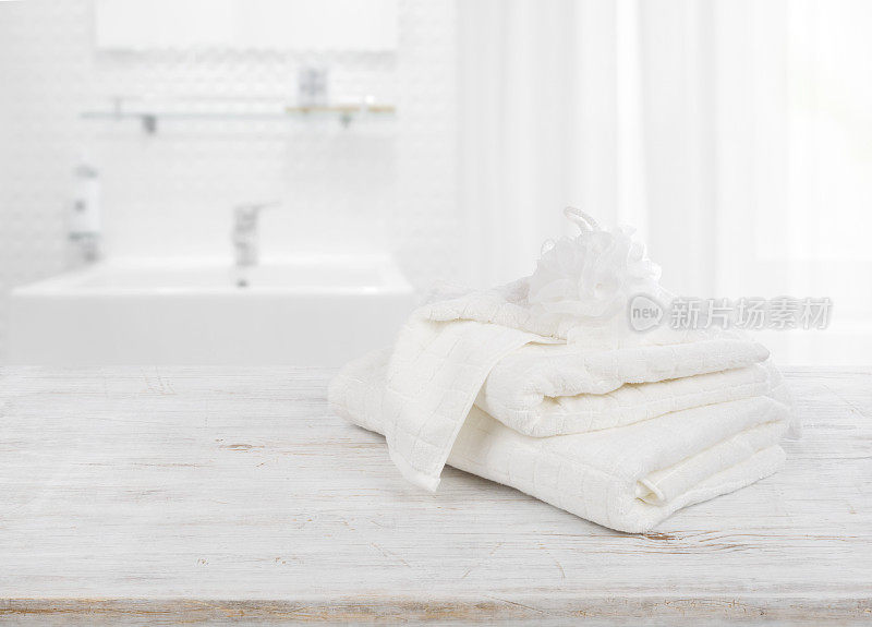 模糊的浴室背景上有松软的毛巾和一缕韧皮