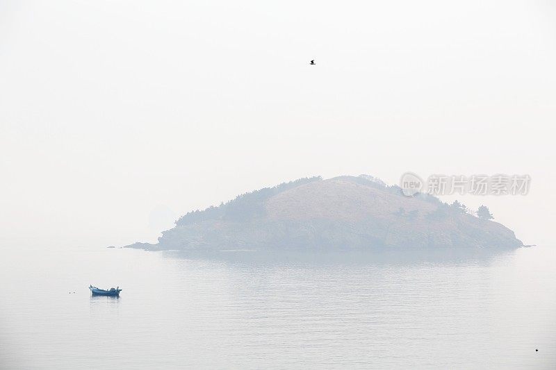 渔船和海岛在雾中