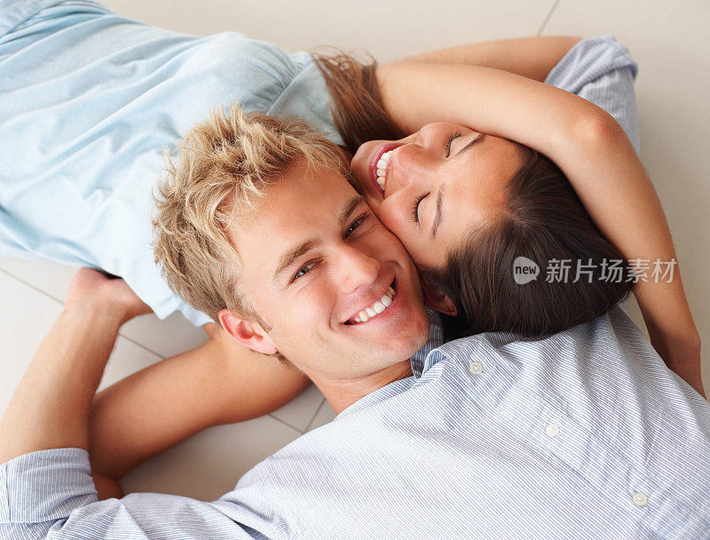 一对可爱的年轻夫妇躺在一起，头靠在一起