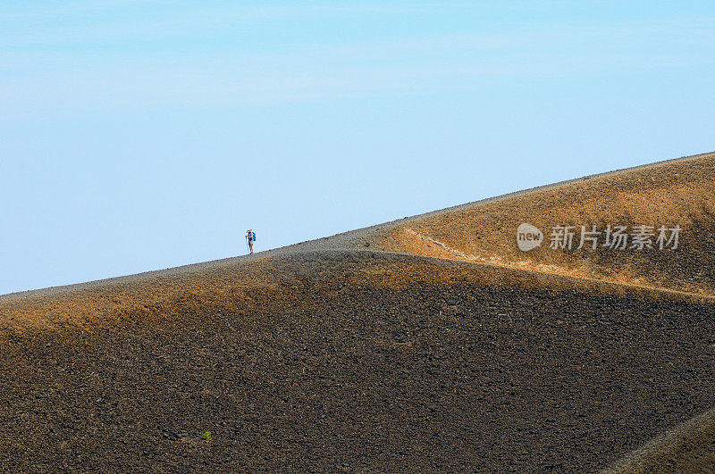 遥远的人在火山边缘徒步旅行