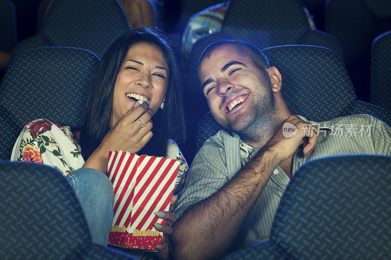 一对夫妇在电影院吃爆米花
