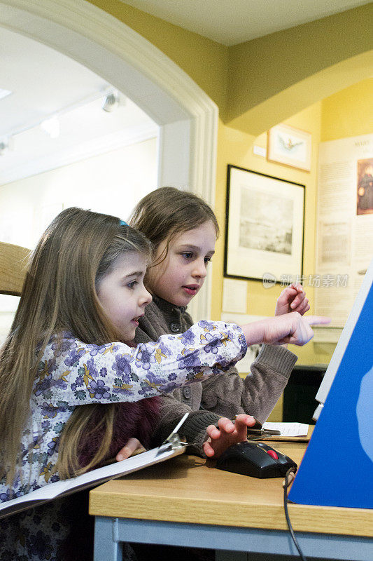 两个女孩在博物馆里用电脑