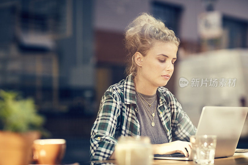 有魅力的女人使用笔记本电脑在咖啡店内的窗口