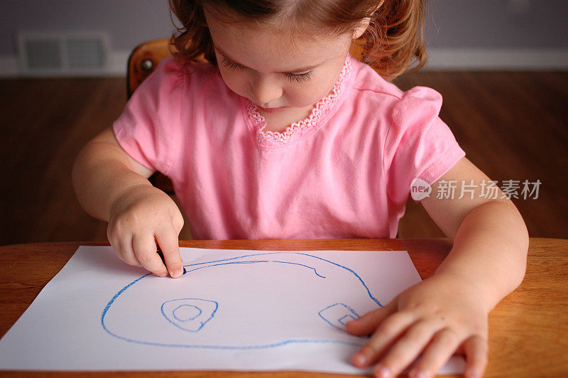 小女孩在纸上画一张快乐的脸