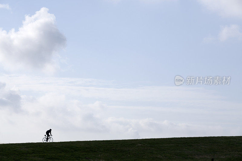 一个骑自行车的人爬山的剪影