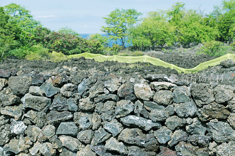 岩石墙和黄色栅栏标志着夏威夷HI的边界