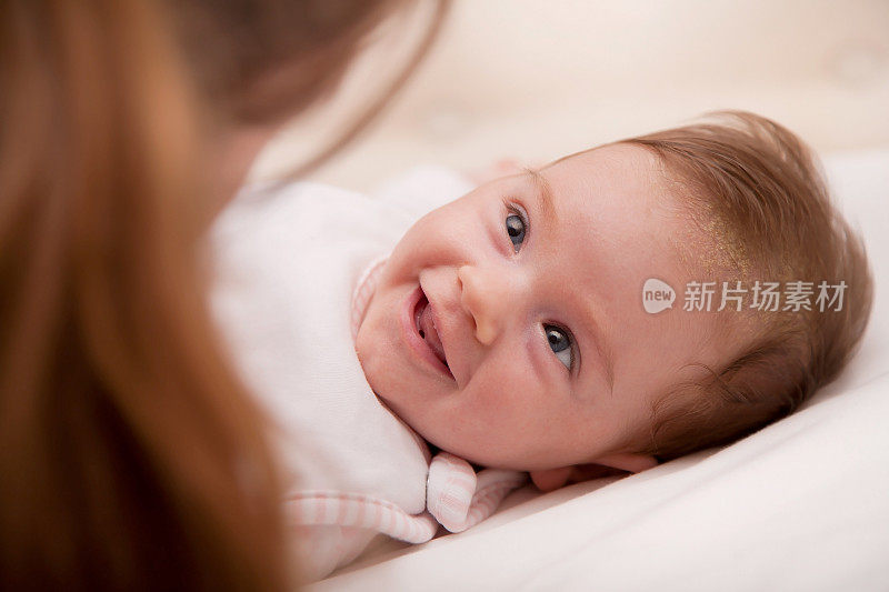 漂亮的婴儿在嘲笑她的妈妈