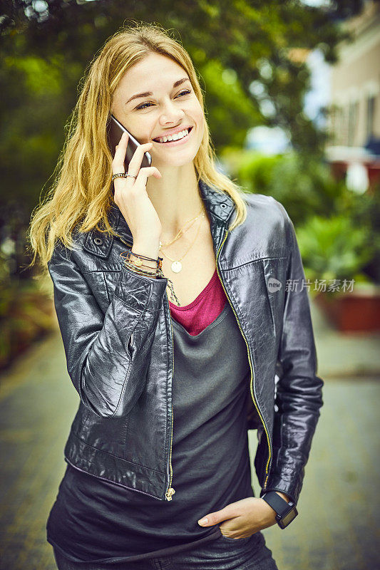 微笑的女人用智能手机聊天，同时看向外面