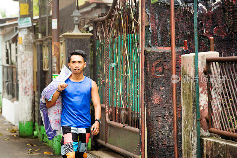 一名印尼男学生周末带着洗好的衣服回家