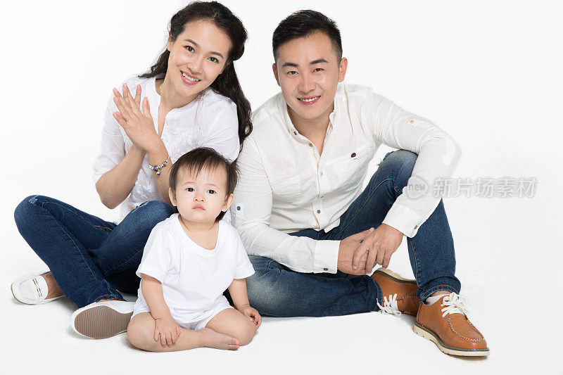幸福的亚洲年轻家庭在白色背景下摆姿势
