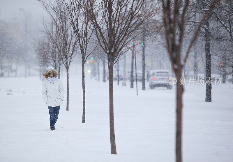 雪下穿着白色夹克的漂亮少女