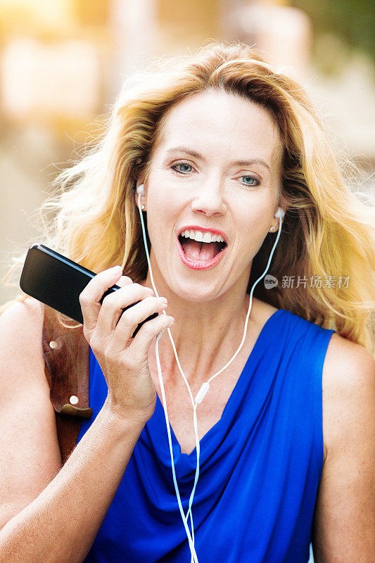 成熟的女人用麦克风耳机玩手机聊天