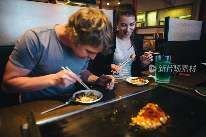 年轻夫妇在自助餐厅吃异国情调的食物