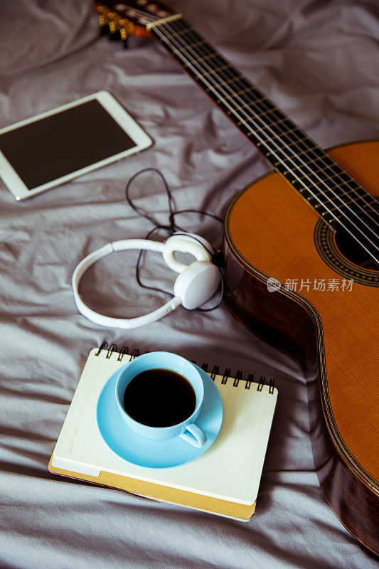 咖啡杯和吉他放在床上