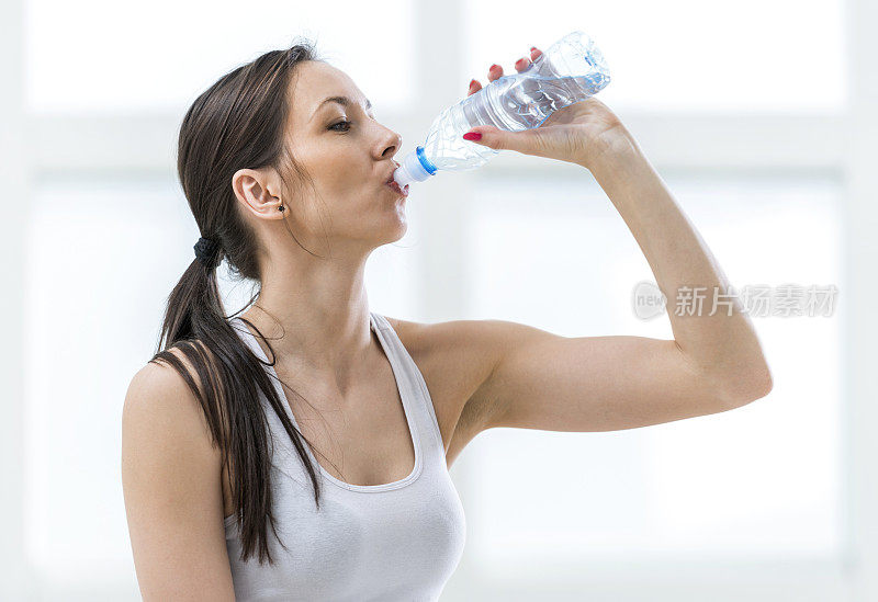 口渴的女人运动后喝水。