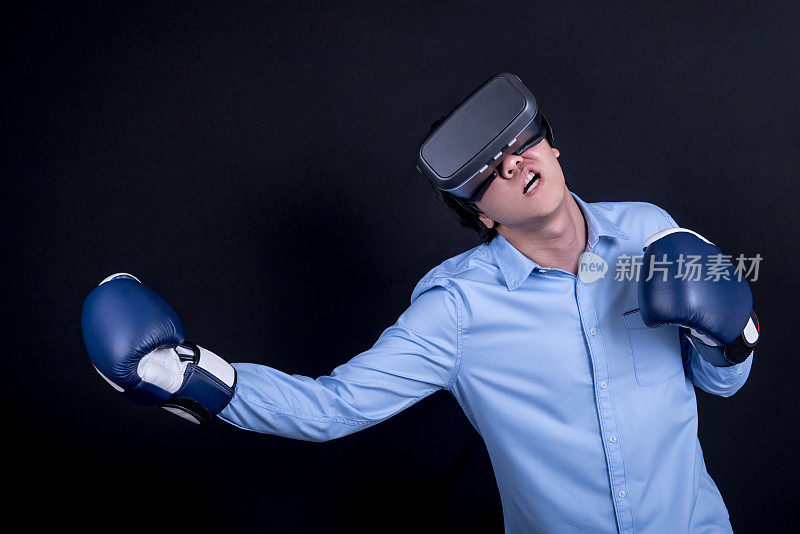 年轻的亚洲男子戴着虚拟现实眼镜在战斗姿势