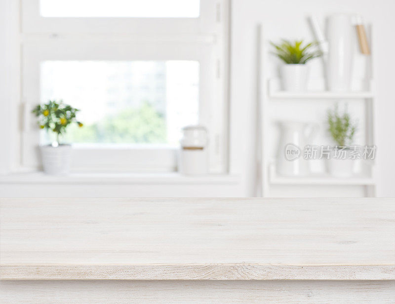 空荡荡的漂白木桌和厨房窗户的架子模糊了背景