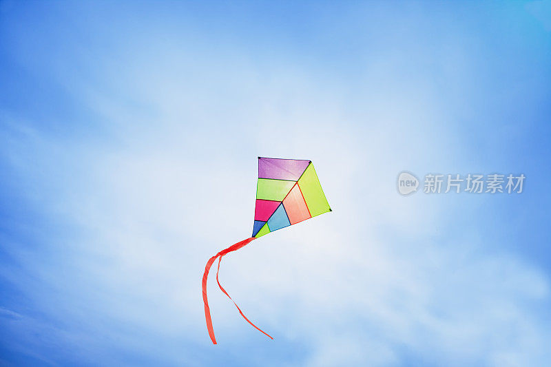 五颜六色的风筝飞着，挥舞着红色的蝴蝶结
