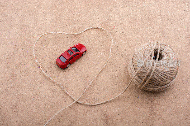 红色的玩具车和一卷线形成一个心形