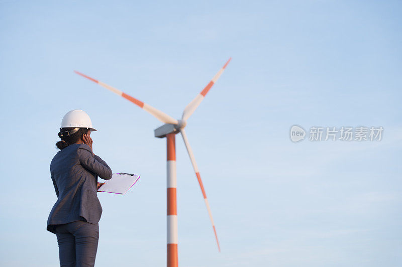 风能工程师检查涡轮机功能。女人摸着风吹的耳朵。