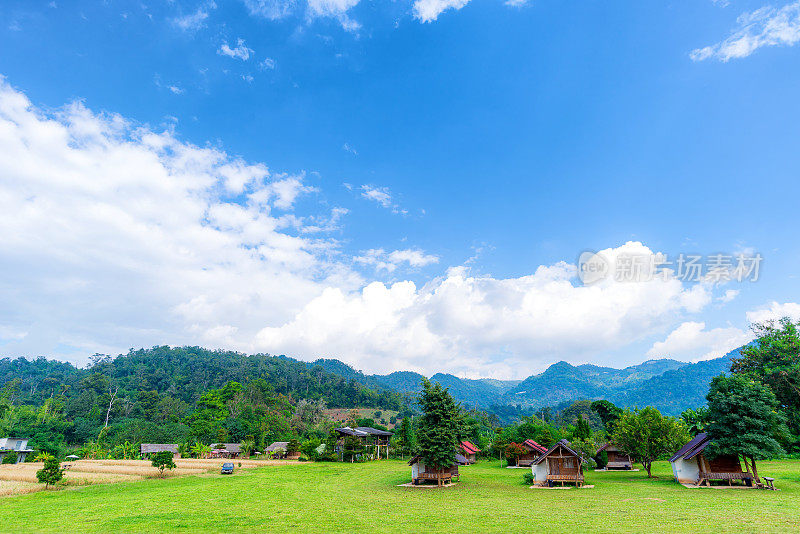 乡村农场和山区的小房子景观，背景是多云的蓝天，感觉宽阔和自由